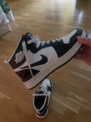 Nike Air Jordan 1 svartvita sneakers - Säljer ett par Nike Air Jordan 1 sneakers. Klassisk high-top modell med snörning, perforerad tå och ikoniska Jordan-loggan på sidan. Är osäker om dom är äkta därav priset! Använda fåtal gånger men annars i bra skick, perfekt för dig som vill sticka ut med streetstyle.💘💘