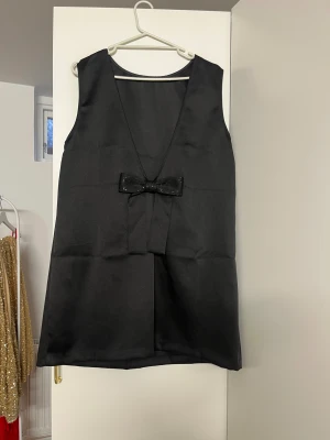 Svart kläning  - Svart kläning med rosett 