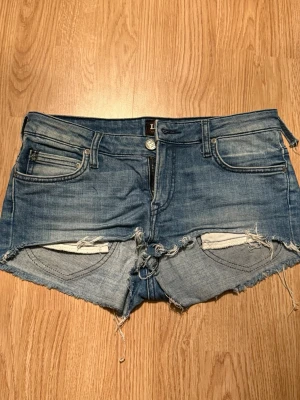 Lågmidjade jeansshorts  - Lågmidjade jeansshorts från Lee. Ena ögglan till skärp har lossnat på höften, lätt att åtgärda 