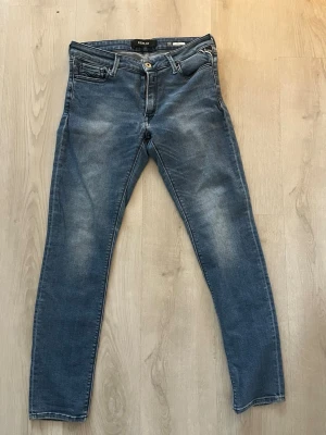 Replay blå slim fit jeans - Säljer ett par blå Replay jeans med passformen slim fit. Det är en snygg blå färg som faseas, byxorna är perfekt för dig som vill vara snygg i vardagen och även i helgen.