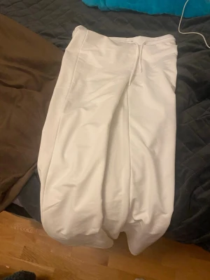 Vita low waist byxor Ebba  - Säljer ett par vita byxor i modellen Ebba Fitted Low Waist i storlek M. Byxorna har låg midja.  skön passform. Materialet känns mjukt och de har en clean look som passar till många olika stilar.Köpte byxorna för ca en vecka sen men provade dem idag och då märkte jag att jag hade för smal midja för att den skulle passa mig, men annars är den i mycket bra skick💕