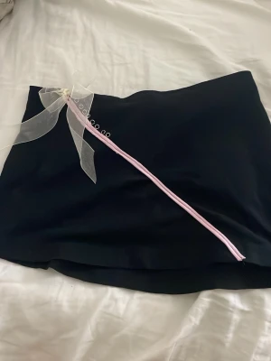 Svart kortkjol med rosett i storlek XS - Säljer en svart kortkjol med en rosett på sidan, har gjort den helt själv, och gör en ny då förra jag gjorde tog slut snabbt! Skriv om fler frågor eller bilder! Det är budning som gäller start är 25kr