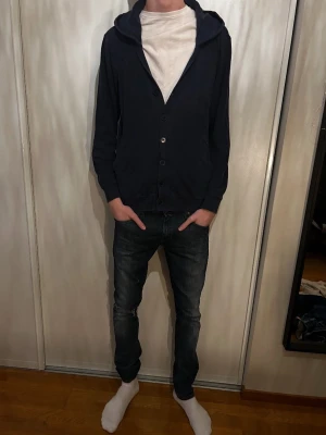 Cardigan med luva - Säljer en mörkblå cardigan med luva riktigt snygg och stilren. Cardiganen  är i storlek M passar verkligen till allt!!!! Sjukt snygg passar till alla årstider ❄️🌼☀️🍁