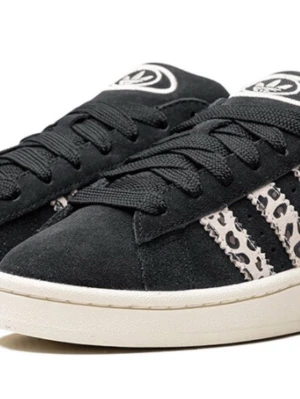 Adidas sneakers med leopardmönster - Svarta Adidas sneakers med klassiska vita ränder i leopardmönster på sidorna. Skorna har snörning och en vit platt sula. Materialet är mocka och de har en rund tå. Perfekt för dig som vill sticka ut med coola detaljer.