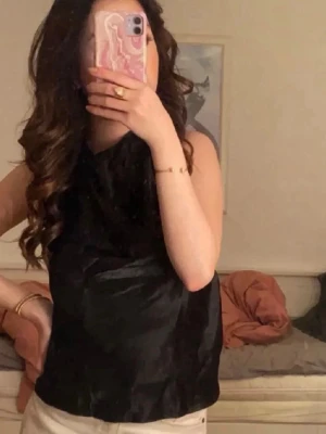 HM topp - Svart glansig halterneck topp fr H&M med dragkedja i sidan. Endast använd 1 gång