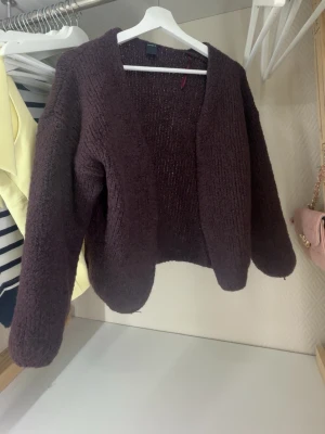 Vinröd  stickad kofta från Lindex - Mysig vinröd stickad kofta från Lindex i storlek XS/S. Koftan har en loose passform, lång ärm och öppen framtill utan knappar. Perfekt för lager på lager under höst och vinter. Superenkel att matcha till olika outfits!