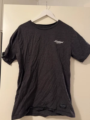 Norrland t-shirt - Säljer en mörkgrå t-shirt från the great Norrland . T-shirten har en vit logga på bröstet och en liten svart patch nertill. Tröjan är i nyskick då den endast använts 1-3 gånger.