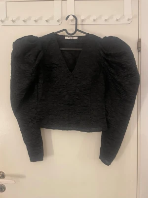 Svart blus med puffiga armar  - Svart blus med puffiga axlar! Super snygg! Storlek 36 från NA-KD. Passar mig som brukar ha XS ( den ser stor ut men det är den inte ) 