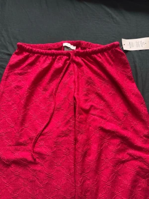 Nelly byxor  - Röda ”mjukis” byxor från Nelly med broderi av blommor på, köpte för att ha till julen men aldrig använt för att de inte riktigt va min smak. Aldrig använts förutom provning. Pm för bild 