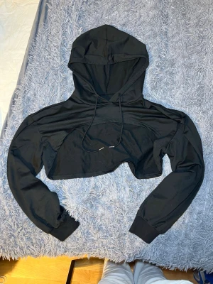 Shein Croppad Hoodie L Svart Polyester - Shein Croppad Hoodie i storlek L, svart färg och tillverkad i polyester. Tröjan har lång ärm och huva, designad för vardagligt bruk.