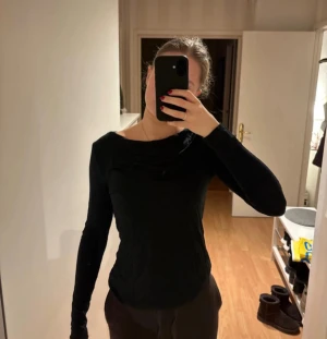Svart långärmad topp från 157 - En svart långärmad topp från 157 i mjukt och stretchigt material. Toppen har en enkel och stilren design med rundad halsringning och smal passform. Köpt för ett år sedan och har använts flertal gånger men inget fel på tröjan!💕