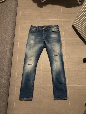 Jack&jones jeans - Säljer dessa as feta jack&jones jeans med en skit snygg tvätt och slitningar. Skicket är bra utan defekter. Storleken är 29/30. Jag på bilden är 170cm lång. Priset kan diskuteras!