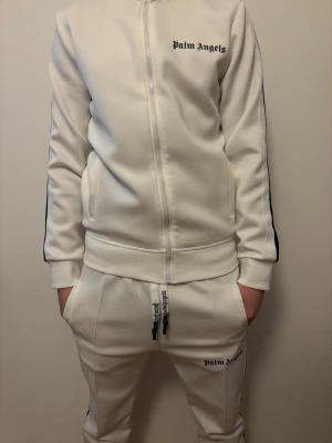 Palm angels tracksuit - Säljer nu min Vita Palm angels dress med svarta ränder, byxorna är använda 2-3 gånger och tröjan är helt ny. Priset går att diskuteras. 2500 för hela settet, för att köpa enskild del skriv i dm. Riktigt bra pris!!
