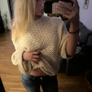 Beige stickad offshoulder tröja - Säljer en beige stickad tröja med grovt hålmönster och breda ärmar. Tröjan har en avslappnad offshoulder-passning och är perfekt för lager-på-lager. Mjuk och skön, passar dig som gillar en chill och trendig look.