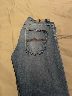Nudie jeans med slitningar - Säljer ett par ljusblå jeans från Nudie Jeans i modellen (grim tim), köpte dom slitna med hål på benen så att jag skulle kunna laga dom. Är kanske inte de bästa lagningarna som gjorts men blev ändå riktigt nöjd med resultatet, utöver lagningarna är dom i ett bra skick med lite slitningar framförallt på fickorna. Om ni har frågor får ni gärna ställa dom!!                        Strl: 34/32, Modell: Grim tim
