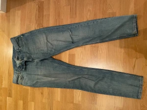 Blåa jeans med hål i knät - Blåa jeans med hål i knät från WHYRED. Storlek 33/34