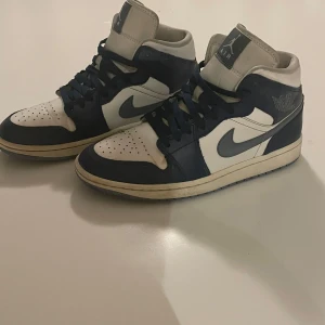 Nike Air Jordans i blått och vitt - Säljer ett par Nike Air Jordans i blått och vitt. Skorna har en klassisk design med snörning och är i mycket bra skick. Perfekta för både vardag och festliga tillfällen. Storlek  40