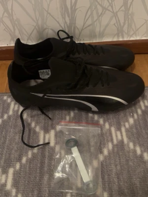 Fotbollsskor Puma Ultra Ultimate  - Helt oanvända skruvdobb fotbollsskor i storleken 43! Köpte dom i tron om att dom skulle komma till användning men så blev de inte så dom är helt oanvända! Får även med en skiftnyckel till skruvdobbarna! 