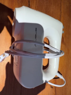 El visp - Bilderna visar en vit elvisp från Emerio med tillhörande vispar och degkrokar i metall, men ingen förpackning med.