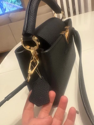 Svart väska  - Säljer en stilren svart handväska. Väskan har både handtag och axelrem.