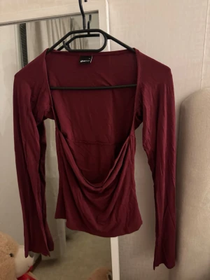 Vinröd omlottopp från Gina Tricot - Säljer en vinröd omlottopp från Gina Tricot med slits längst ner vid armen🎀