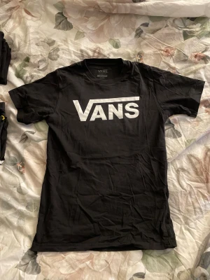 Svart Vans t-shirt med stor logga - Säljer en svart t-shirt från Vans i klassisk passform och stor vit Vans-logga på bröstet. Finns inga fläckar eller hål i tröjan, sälja pågrund utav att den aldrig kommer till användning.