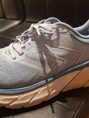 Ljusblå sneakers med tjock sula - Säljer ett par ljusblå sneakers med vit och blå tjock sula. Skorna har snörning och är tillverkade i ett ventilerande syntetmaterial. Perfekta för dig som gillar sportig stil och vill ha bekväma skor till vardagen.