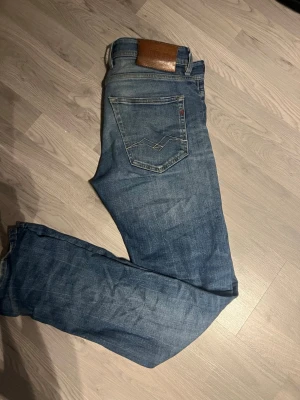 Blå Replay jeans straight fit 28/32 - Säljer ett par klassiska blå jeans från Replay i rak modell. Jeansen har fem fickor, snygga slitningar och Replay-logga på bakfickan. Tillverkade i slitstarkt denim med normal passform och midja. Perfekta till vardagslooken.