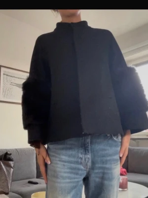 Svart pälsjacka med vida ärmar - Väldigt populär och stor efterfrågan!Säljer en svart pälsjacka med raka linjer och vida ärmar som har fluffiga detaljer. Jackan har hög krage och en stilren, minimalistisk look. Perfekt för dig som vill ha en unik och trendig jacka till höst och vinter.