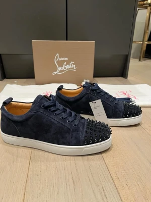 Blå louboutins med spikar - Snygga mörkblå sneakers i mocka från Christian Louboutin. Lådan och påsarna har tappats bort men vinted taggen finns kvar. Storlek 42 helt nya pris kan diskuteras.