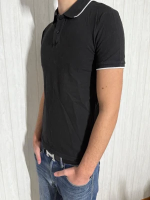 Svart pikétröja med vita detaljer - Säljer en svart pikétröja ifrån H&M, den är i gott skick och är i storlek M. Vid fundering är det bara att hojta till !