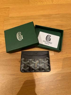 Korthållare - Säljer ett stilrent kortfodral i svart skinn med klassiskt mönster och gul insida. Perfekt för dig som vill ha något lyxigt och smidigt i fickan. Kommer med original ask och kort.