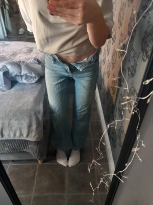 Ljusblå wide jeans från H&M - Säljer ett par ljusblå jeans från H&M med hög midja och justerbar midja. Modellen är wide med raka ben och klassisk femficksdesign. Jeansen är i mjukt denimtyg och har en avslappnad passform som ger en chill vibe.