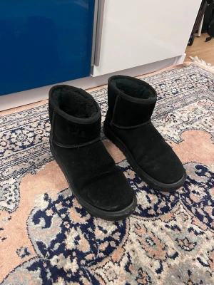 Svarta boots/uggs - Mysiga svarta boots i läder med mjukt foder på insidan. Skorna har rund tå, platt sula och är perfekta för kalla dagar. Klassisk enkel design som passar till det mesta. Från dinsko