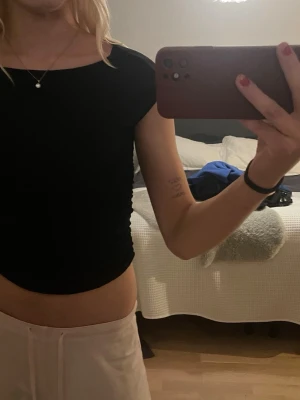 Svart croppad topp från Amisu - Svart croppad t- shirt som är ribbad i sidorna.