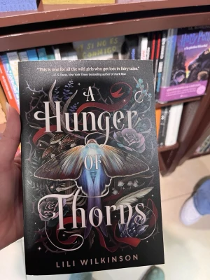 A Hunger of Thorns - NY bok (oläst) - Hunger of Thorns är en mörk fantasyroman med inslag av romantik, magi och farliga hemligheter. Berättelsen handlar om makt, förbjudna känslor och en värld fylld av intriger.  Boken är ny och oläst, endast bläddrad i kort. Inga anteckningar, veck eller skador (se bilder).  📖 Språk: engelska 📚 Skick: ny 🚭 Rökfritt hem  Kan skickas eller mötas upp enligt överenskommelse. Skriv gärna om du har frågor! 