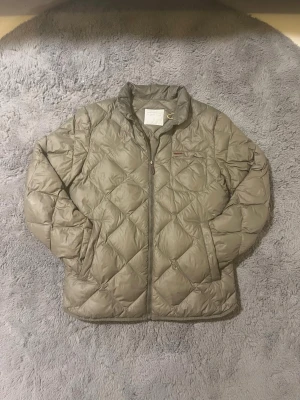 Peak Performance dunjacka/ vinterjacka - Säljer en olivgrön quiltad dunjacka från Peak Performance i storlek M. Jackan har dragkedja framtill, hög krage och en bröstficka med läderdetalj. Insidan har en gul dragkedjeficka. Perfekt för vinter, höst eller vår. Om du har några frågor eller vill se fler bilder är de bara att skriva!🙂 priset kan diskuteras vid snabb affär.