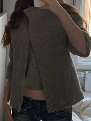 Grå tygjacka med trekvartsärm - Säljer en grå jacka med öppen framsida och trekvartsärm. Den har en enkel och clean look, perfekt att slänga över en topp för en chill vibe på våren o hösten. Passar dig som gillar en avslappnad och stilren stil.🙌💕 Vet ej exakta storlek men passar mig som är en xs/s!