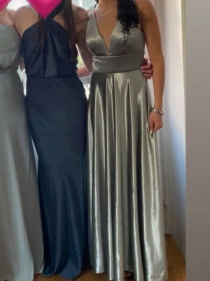 Silver/grön färgad balklänning med v-ringning - Säljer en elegant silver/grön färgad långklänning i glansigt material. Klänningen har djup v-ringning och utsvängt kjolparti.Klänningen är använd endas 1 gång och köpt för 1199kr,den kommer även i original förpackningen,det står att storleken är 36 med hade sagt mer mellan 34-36 eftersom den inte kommer till användning så säljer jag nu den för ett bra pris,Den är perfekt för dig som letar bal klänning eller en lite mer elegant klänning för speciell tillfälle,skriv för frågor pris kan diskuteras💕