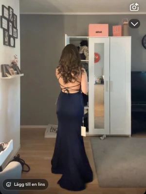 Balklänning marinblå - Säljer en jätte fin balklänning som är marinblå med en öppen rygg. Den är sydd till mina mått i längden och jag är drygt 162 och den passar jättebra i längden, sen har klänningen släp där bak också som syns i bilden💗kom med alla sorts olika bud!