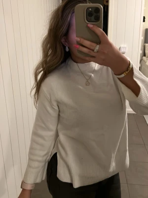 Vit stickad tröja från 157 XS - Säljer en enkel och clean vit stickad tröja från 157 i storlek XS. Tröjan har ribbade muddar vid ärmslut och nederkant samt en högre rund hals. Perfekt till lager på lager och funkar till allt.