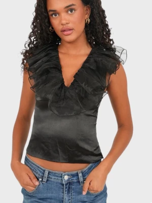 Svart ärmlös volangblus i satin, fest topp - Supersnygg svart blus i satinliknande material med djup v-ringning och stora volangdetaljer runt halsen. Ärmlös och figurnära passform som ger en elegant och trendig look. Perfekt att styla med jeans eller kjol för en cool outfit. Den är ej använd och har fortfarande prislappen på. Storlek Xxs/xs. Från Meet Me There