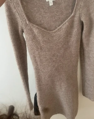 Beige stickad långärmad tröja H&M - Säljer en beige stickad tröja från H&M i storlek XS. Tröjan har en snygg v-ringad hals och ribbad struktur som ger en schysst look. Långärmad och i mjukt material som passar perfekt när det är lite kyligare ute.
