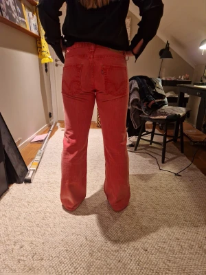 Levi's bootcut - Säljer ett par Levi's 512 bootcut jeans i en cool röd/rosa färg. Perfekt för dig som vill sticka ut och rocka ett bar feta brallor!