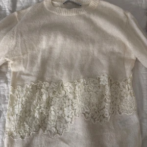 Vit stickad tröja med spets från Zara - Superfin vit stickad tröja från Zara med en fin spetsdetalj på tröjans mitt. Sälja inte längre på Zara och dessutom har jag knappt använt den❤️