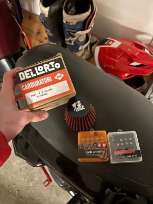 Dellorto PHBN 17.5 LS Carburetor Kit - Säljer ett Dellorto PHBN 17.5 LS förgasarkit, komplett med luftfilter och två olika munstyckssatser (Stage6 och Dvision). Allt ser nytt och oanvänt ut, perfekt för dig som vill optimera din moped eller motorcykel. Inga synliga defekter eller slitage.