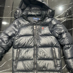 Ralph Lauren Jacka - Säljer nu min svarta/mörklblå pufferjacka från Polo Ralph Lauren i storlek xs pga jag växt ur den. Jackan har varit väl omhändertagen och har inga defekter. Skickar ej iväg då jackan är så dyr. Upphämtning finns i Stockholm. Hör av er vid fler frågor!💯 