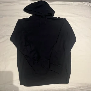 Marinblå hoodie från RYVLS Stockholm med huva - Marinblå hoodie från RYVLS Stockholm i storlek s. Tröjan har en klassisk huva med snörning och långa ärmar. Materialet är mjukt och stickat, perfekt för chill dagar. Enkel och stilren design utan tryck eller mönster.