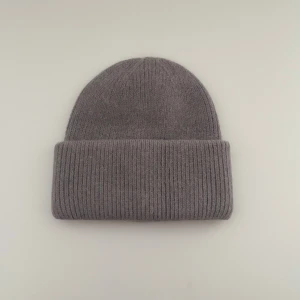 Grå  mössa  - En stilren grå mössa med bred uppvikt kant och ribbad struktur. Tillverkad i mjuk ull som håller dig varm under kyliga dagar. Enkel design som passar till de flesta outfits och är perfekt för höst och vinter.