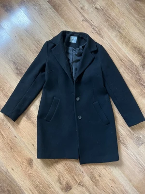 Svart kappa Lindex - Svart medellång kappa från Lindex i storlek S. Lite tjockare och passar perfekt för både höst, vinter och vår. Utmärkt skick! Kolla gärna in mina andra annonser och lägg gärna bud på bundle!